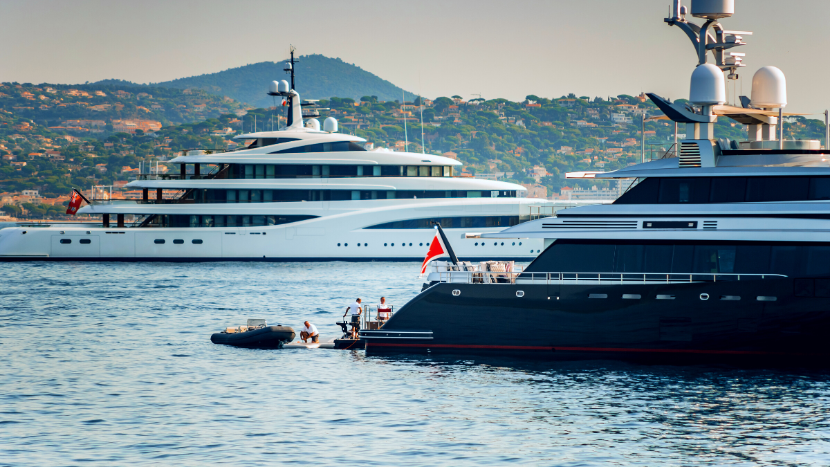 Two Superyachts at sea in front of island